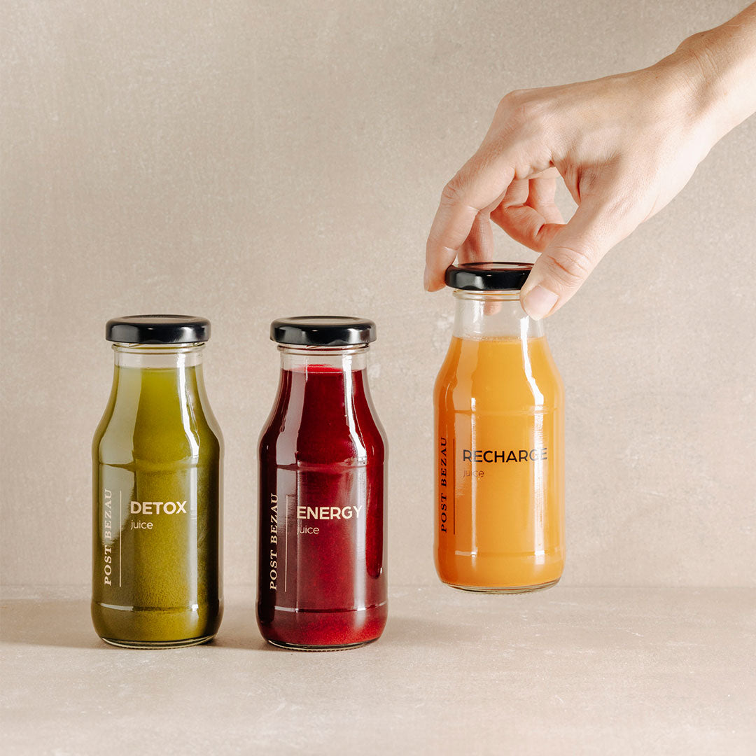 Drei POST BEZAU Juices nebeneinander, eine wird gerade weggenommen