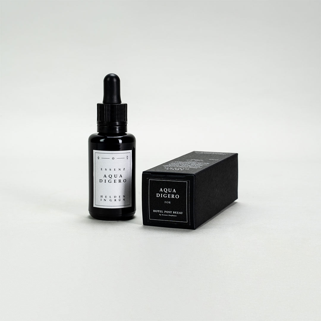 Essenz Aqua Digero von Helden in Grün in Glasflasche mit Verpackung liegend